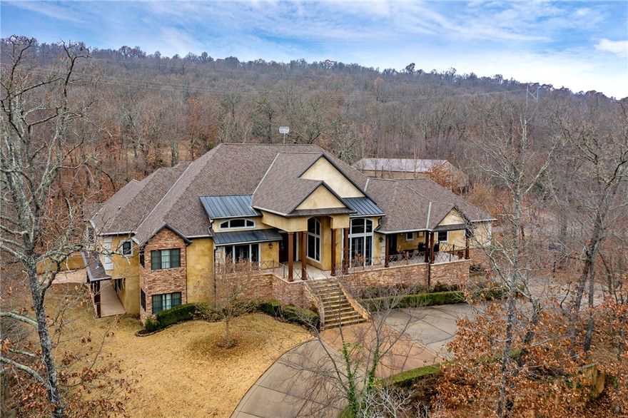 Breathtaking custom built gated estate on 8.65 forested acres in East Fayetteville. On the main floor are the formal living & dining rooms, wet bar, master suite with impressive closets, a guest suite, an office with beautiful cabinetry, incredible kitchen with a large pantry, informal dining area & den with a fireplace. On the lower level you will find two additional bedrooms, a game room, an exercise room and a family room. The home utilizes geothermal energy for heating & cooling. The property also has a 2,400 square foot shop/storage building. Recently there were updates done to bathrooms and the kitchen, and some areas of the home have been freshly painted.