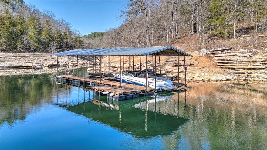 Lakefront retreat on Beaver Lake just 15 minutes from Downtown Rogers dining and entertainment. This distinctive 3 level cabin offers elevated lake living with vaulted ceilings, open-concept design, and expansive wraparound decks on multiple levels for seamless indoor-outdoor living. The upper-level primary suite is a private escape with serene lake views. The lower level features two additional bedrooms, a second living area with wood burning stove, and a bonus room with gun safe ideal for guests or flexible use. A private walking trail leads directly to a 2 slip dock and the clear waters of Beaver Lake, providing rare true lakefront access. Designed for both relaxing and entertaining, this property delivers the ultimate lake lifestyle with space, privacy, and unbeatable proximity to Rogers.