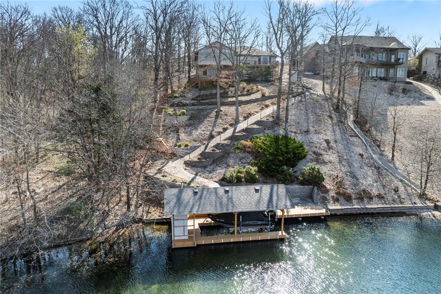 Stunning Lakefront Home with Covered Boat Dock on 1.01 Acres! The eat-in kitchen offers granite countertops, plenty of cabinetry and pantry, all appliances convey. The open living area has hardwood floors, a gas fireplace, and lake views. The primary bedroom (with lake view) and second bedroom/office are on the main floor, along with an all-season sunroom with a mini-split system. A large laundry room with washer and dryer that convey. The finished walkout basement includes two bedrooms, a kitchenette, and large family room with a second gas fireplace. A 15x20 workshop for projects or storage. Outside, enjoy entertaining on the deck or patio. The covered boat dock has a lift and storage.  Updated stone walls, new wood steps/walkway to the dock, and new gutter guards. The oversized 3-car garage comes equipped with traction mats.
Don’t miss this rare opportunity—schedule your private showing today!