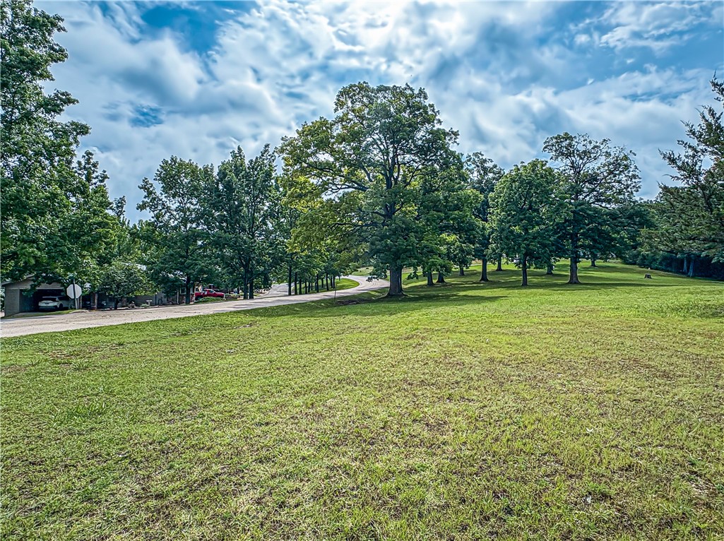 A rare chance at a single parcel totaling 1.01 acres in Holiday Island. Appearing park-like with beautiful and mature hardwood trees, this oversized lot is located just across the street from a premier golf course, community pool, tennis and basketball courts, and just a short drive to the Holiday Island Marina. Level and partially cleared and ready for your dream home. A developers dream! Lot has been surveyed for a potential 4 building sites ranging from .23 to .32 acres. City water, sewer and electric at street. Adjacent home and .54 acres also listed for sale under MLS #1313193.