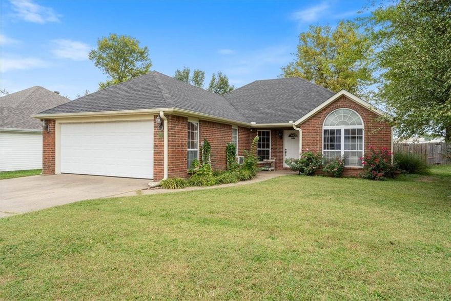 Perfect Location! This charming 3-bedroom, 2-bath home sits in the heart of Siloam Springs—close to shopping, schools, and local parks. The open floor plan features a spacious living room with cathedral ceilings, hand-scraped wood floors, and a cozy gas log fireplace. The eat-in kitchen offers ample counter space, a pantry, and tile floors in all wet areas. The primary suite includes a tray ceiling, walk-in closet, double sinks, a relaxing jetted tub, and a separate shower. Enjoy peaceful afternoons on the deck or under the shade of mature trees in the privacy-fenced backyard. Additional highlights include carpeted bedrooms, attic storage, and a portion of the garage converted into heated and cooled living space—adding approximately 200 sq. ft. of versatile bonus area. New HVAC in 2019; New gas range 2025. New roof coming October 2025!