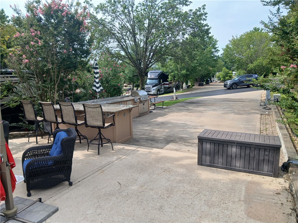 This beautifully landscaped lot is a pull-in and will accommodate up to a 45ā motorhome ( class A, and C) full hook ups with 30/50 amp power, parking space for golf cart and car(s). It offers a beautiful outdoor kitchen complete with large gas grill, gas 2-burner stove, refrigerator and sink, plus storage drawers and cabinet storage below, and is complemented with granite countertops. An additional large patio provides a great place for your outdoor furniture and spending your leisure time. There is also a centrally located guest pool, as well as an ownerās pool and clubhouse. A convenient on-site courtesy dock is available for guests who enjoy boating. Furnishings will not convey. 30 minute drive to Branson