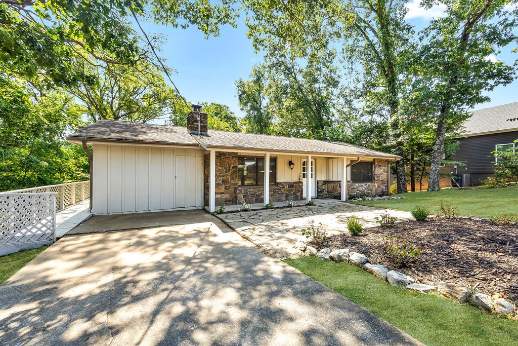 Adorable property in the Shropshire Subdivision! Completely transformed and beautifully remodeled inside and out, including fresh paint, all new flooring, fixtures, countertops, and much more! Wonderful floorplan has neutral colors, led lighting and beautiful natural light with open design. Rock fireplace gives a warm and cozy ambiance. Lovely eat-in kitchen is equipped with large center island and stainless steel appliances. Separate laundry room gives organized functionality. Spacious bedrooms provide privacy and practicality for the whole family. Primary suite offers large walk-in closet, dual sink vanity and custom tiled walk-in shower. Additional storage throughout. Back deck has beautiful wooded views and additional storage options below. Bella Vista Country Club & Golf Course is less than 10 minutes away, with lakes and trails just moments away. Move in ready and waiting for you!