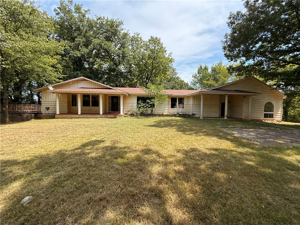 Secluded retreat hidden in a park-like setting. This hard to find jewel has approximately 20 acres with close proximity to everything NW Arkansas has to offer also just a short drive across the line to Oklahoma. Over 3000 sq ft ready to call home. Formally a dog grooming set-up that could be transformed to fit your unique needs, use your imagination! Wooded acreage provides a canopy for wildlife or walking trails. With some updating this property can be restored to a beautiful estate.