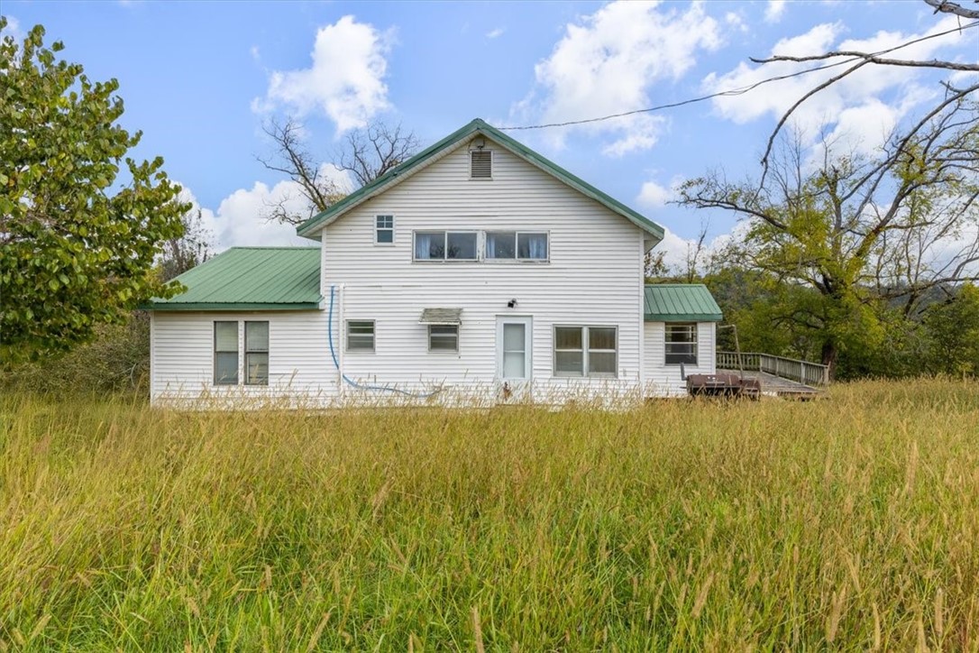 Step back in time with this 1900-built country home full of charm and character. Perched atop a gentle hill on 2.8 scenic acres, this 1,630 sq ft home offers stunning views of the surrounding countryside. From the covered front porch, enjoy peaceful mornings and sunsets with no close neighbors in sight. Inside, you'll find original touches that give this home a warm, nostalgic feel, along with spacious living areas ready for your personal updates. A standout feature is the large workshop—perfect for hobbies, storage, or projects—and it includes a cellar/safe room for added peace of mind. With open land, mature trees, and a private setting, this property is ideal for those seeking quiet rural living, a mini homestead, or a unique restoration project. A rare opportunity to own a piece of history in a beautiful natural setting.