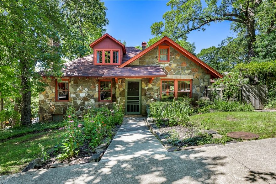 This enchanting Wilson Park “Rock House” was built by renowned UofA geologist Dr. Noah Fields Drake.  The hallmark exterior features locally quarried sandstone, timeless craftsmanship.  Price per SF allows a buyer to personalize the interior with fresh paint, refinish wood floors, update kitchen & more.  Has 2 updated bathrooms.  Located within a block of Wilson Park, the romantic bungalow features a peaceful, secluded yard on a 2nd platted lot, complete with mature hardwood trees and a stone patio.  The delightfully shaded screened porch on the North side is perfect for relaxing on warm days.  The cozy, functional layout includes original details such as a built-in hutch between the dining room and kitchen, plus charming windows and doors. The home offers 2-3 bedrooms: two on the main level and a private upstairs suite. The versatile front living room can serve as a 3rd bedroom, with space for armoires if desired. A 2nd living area off the kitchen adds to the home's relaxed feel.  A unique and rare opportunity!