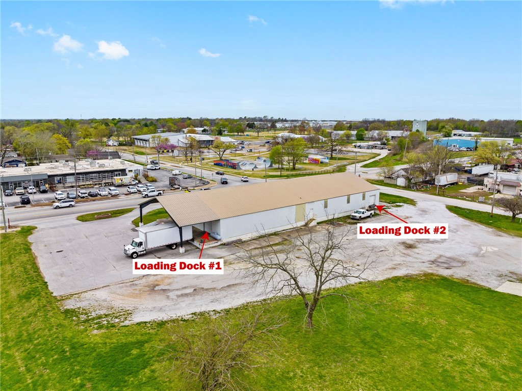 Prime +/- 9,000 SF warehouse/office space available near Downtown Rogers! This high-visibility property on busy 2nd St offers excellent exposure with an impressive traffic count of approx. 15,000 VPD. The building features two loading docks, one with an 8' tall door and the other with a spacious 10'x10' door. Inside, enjoy tall ceilings with a maximum height of 21.5 feet at the center and 12 feet along the sides, perfect for flexible storage and workspace needs. The layout includes two offices and a private restroom, all set on a sprawling +/- 1.8 acre lot, providing ample space and accessibility.
