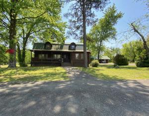Beautiful log home! This large log home on 5 acres features beautiful pegged wooden floors, stonework and authentic solid log construction. The 5 acres is cleared, includes some fencing and a large barn. Balcony overlooking the beautiful countryside. 3 car detached garage. Large covered porch and deck for above ground pool (pool has been removed). Drive in basement. 4 bedrooms, 2 bathrooms, and 3 awesome stone fireplaces!