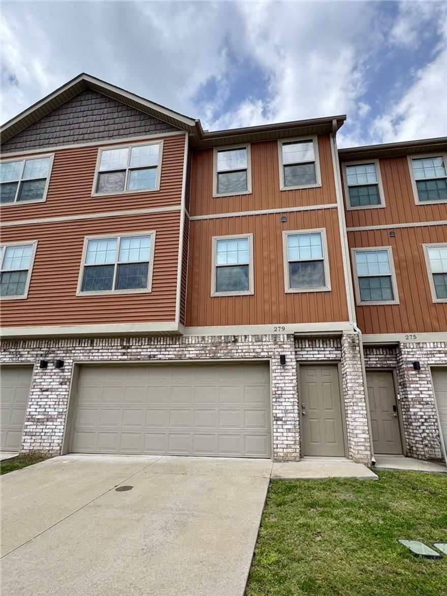 This townhouse is ideally located just minutes from the University of Arkansas campus and close to a wide variety of dining and shopping options. The three-level layout offers a garage on the first floor, with the main level featuring an eat-in kitchen, living room, dining area, and half bath. Upstairs, you’ll find two bedrooms, including a primary suite with a private bathroom and walk-in closet, along with an additional full bath and a convenient laundry area.
The kitchen is equipped with stainless steel appliances, granite countertops, and a center island. The home has been freshly painted and is move-in ready, with new flooring throughout, including pine wood stairs. A deck just off the kitchen provides the perfect space for outdoor dining or relaxing while enjoying the peaceful wooded area behind the property.