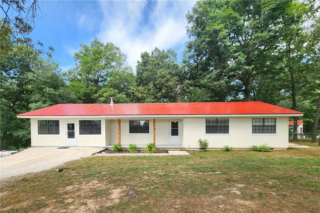 Move in ready, 3 bedroom and 2 bath home, on the outskirts of town! Home sits on 1 acre that borders our beautiful Withrow Springs State Park. Recent renovations include a new 26 gauge metal roof, new vertical vinyl siding, new carpet, paint, lighting, storm doors, and more! Open living, kitchen, and dining. 3 spacious bedrooms with ensuite bathroom in the primary bedroom, and jetted tub in guest bathroom. Primary bath has wall mounted propane heater and guest bath is plumbed for the same. Large laundry/mudroom with walk in pantry and access to additional storage in a small cellar. Enclosed garage gives you the option for a fourth bedroom, another family room, home business, or more! You will have plenty of room for entertaining with the beautiful wood-sided and screened-in back porch, which is already plumbed for your propane grill and fireplace. Back yard is fenced with a leveled space for outdoor dining and a concrete slab with electric hook-up for your future hot tub. Make your appointment today!