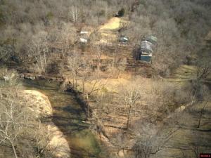 Amazing 13+ acres overlooks 2 creeks with land on both sides of Clear Creek. Stand on your bluff and look down at the trout. Count the deer from the 12 x 20 front deck which is high in the sky and feels like you are in a treehouse. Private end-of-the-road setting with guest cabin, studio, carport, storage building & 30x50 2 story workshop with bath. LL has separate entry with two 2room suites perfect for weekly rental income .Preppers paradise, just add solar power and get off grid.