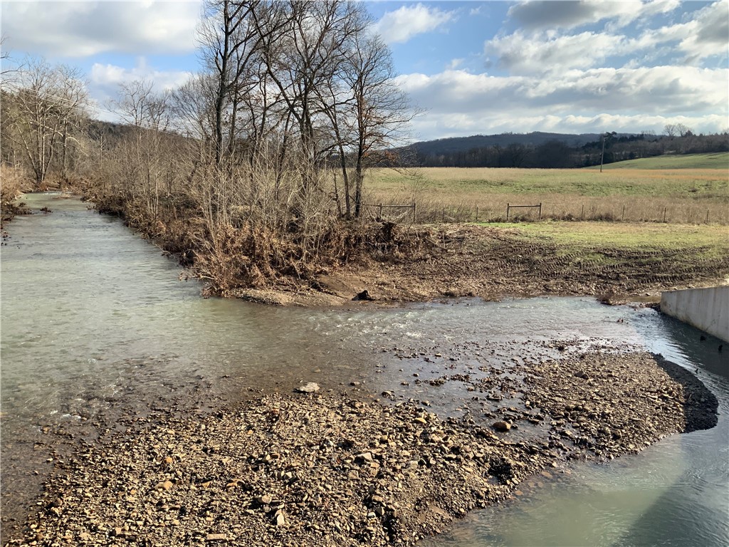 Come see this beautiful, partially wooded, gently rolling, 103 m/l acres. Year-round live water with approximately 1 mile of Henderson Creek along the eastern boundary. Paved highway frontage, rural water, fiber optic and power on site for your dream home or development. Nice views, 3 ponds, 20 acre m/l hayfield, old barn with corral. Only a short 7 mile drive south of Huntsville and 40 minutes to Fayetteville/Springdale. Enjoy a country setting while being close to all amenities. Lots of desirable features and opportunity in this prime property! Utility availability is the responsibility of the buyer or buyers agent.