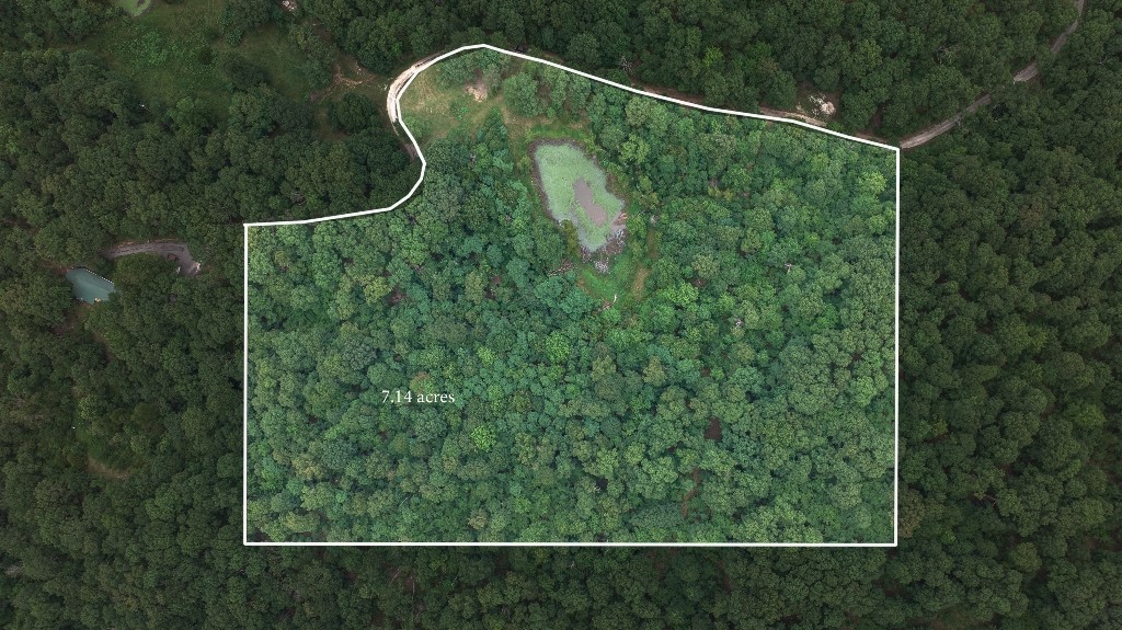 Coming home to this 7.14 acre is a blended adventure with nature and wildlife. Curve with scenic paved interior road as you drop down into an elevated valley where the fog often rolls up in the early morning beside the large picturesque pond. You will feel totally removed while experiencing the best of NW Ar. only 20 minutes from the University of Ar. at Fayetteville. Enjoy as a retreat or for build your dream home.