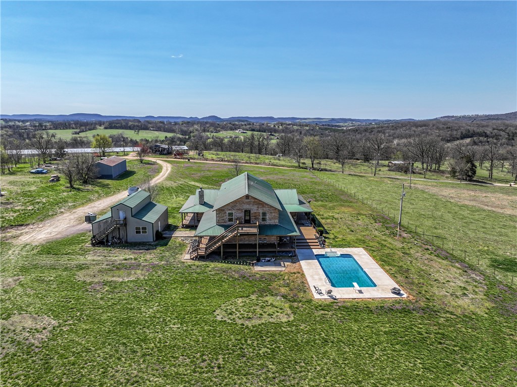 Extraordinary opportunity! this beautiful 6 bed, 3.5 bath home sits on 9 plus acres outside the city limits. It would great for a large family OR a an out of the way, go to wedding venue. Upstairs you have 5 bedrooms plus 2 bathrooms and a large family room. Downstairs you have a Master bedroom, bath and Large open great room that includes a fireplace with a living room, modern kitchen and a dining room. The flooring throughout is wood laminate and ceramic tile. The master bath has a jetted tub, shower and walk in closet. The ceilings are tongue and groove. Both floors have washing rooms, one with a mud room. There are 2 electric ranges, a dishwasher and a refrigerator. One of the washing rooms has the washer and a propane dryer in it. Outside you have a shop, a building for storage and a two story shop you could convert to another kitchen. Plus, there is an inground swimming pool to swim or relax in with an great view of the valley below. Property has good working wells.