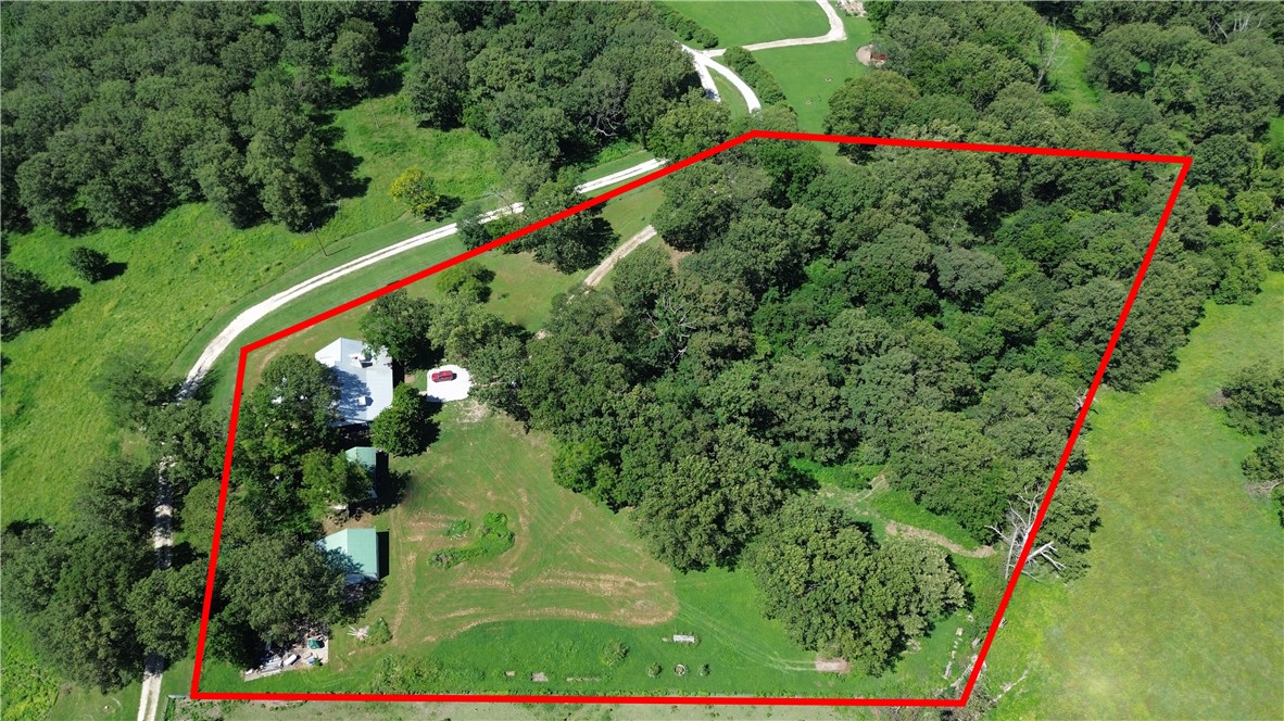 Beautiful secluded 6-bedroom, 3.5-bath home on 5 acres, perfect for privacy and scenic living. Recently refurbished with a modern touch, featuring a new kitchen with quartz countertops, new cabinets, and appliances. The home boasts wood floors and tile throughout, two primary suites on the main level, one with gas log fireplaces, and a versatile bedroom that can serve as a study or family room. The large butler’s pantry offers ample storage. Enjoy cozy evenings by the wood-burning stove or the gas fireplaces. The spacious front porch invites relaxation, while the fresh paint, new hardware, vaulted wood ceiling, and new fixtures add a touch of elegance. The property includes a 27x27 shop with a 12-foot door and cement floors, and a 3-bay loafing shed that doubles as a 3-car carport. A tranquil oasis perfect for extended living or a private retreat. Schedule your showing today!