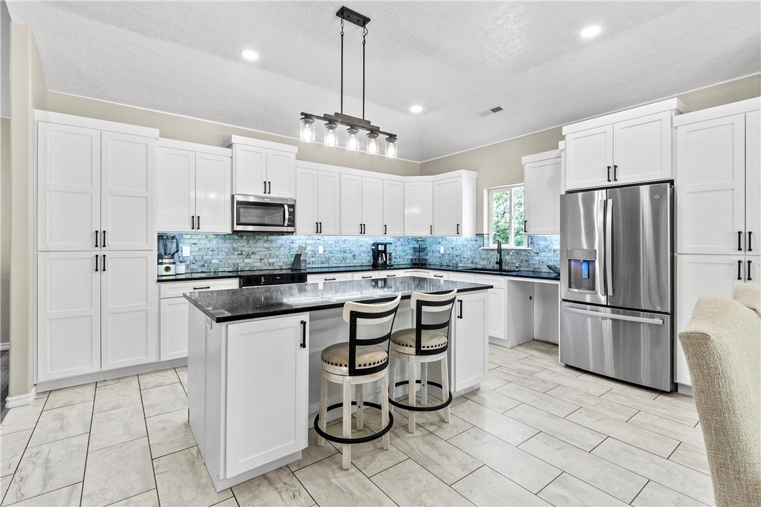 Your dream retreat awaits—5.46 acres of peace and beauty surround this stunning, nearly new home. Completed only a year ago, it boasts vaulted ceilings, an open floor plan, and an abundance of natural light that highlights every spacious room. The premium kitchen is a showstopper, featuring exquisite quartzite countertops and superb design that makes it both functional and beautiful. The primary suite is a true retreat, complete with large his-and-hers closets and a spa-like bathroom offering dual vanities and a relaxing jetted tub. Whether you’re entertaining or unwinding, this home checks all the boxes for elegance and comfort.