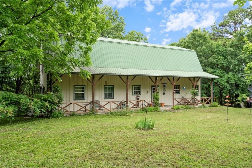 Private Hillspeak retreat located just 3 short miles from vibrant Eureka Springs. This lovely and well maintained barndominium is nestled in the country on 8 1/2 wooded acres with a huge, flat, landscaped,  fenced in front yard. Upon entering you will be delighted with the bright and airy open floor plan that seamlessly connects the living, dining, and kitchen areas. Extremely high ceilings and large windows flood the space with natural light. Large sliding glass doors beckon you to go enjoy the back deck and gorgeous flaming red maple. The guest room is conveniently located on the main floor & is adjacent to a full guest bath. Upstairs the Primary suite loft is an expansive 1320 sq. ft. with a large office or gaming/TV area, exercise area, walk in closet, full bath with double vanity, & even a library/study nook. Plenty of room in the double garage for the truck and a small boat! Big Clifty boat ramp and swimming area are just a few miles south. You will also be close to the Kings, White and Buffalo National​​‌​​​​‌​‌​​​‌‌​​​‌‌‌​​‌​​‌‌​​​​ River