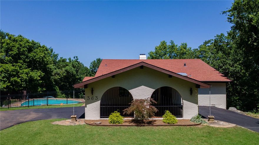 This Mediterranean, Mid-Century Modern home is amazing. Located on 1.45 secluded acres at the base of Kessler Mountain. Inside, you’ll find a remodeled kitchen with Cotto tiled floor, leathered granite, Talavera tile backsplash, Chef’s grade Verona gas range and eating area.The living room boasts a vaulted ceiling with porcelain tile wood floor, ornate wooden beams & built-ins. 4-sided native stone fireplace & unique custom wood Masonite wall paneling in huge living room. Enjoy the 500 sqft screened-in terrace w/ arches as a prime entertainment space. BRAND NEW CARPET in bedrooms. The exterior, with BRAND NEW PAINT, is authentic stucco with portico, arched Pella glass doors & windows w/ custom wood shutters. A stone decked saltwater pool overlooks the mature trees and large Artesian well fed pond. Spanish iron hand blown amber glass light fixtures.Basement workshop. New asphalt drive.Minutes to I49 & UofA. Fayetteville Schools. Additional adjoining 3.22 acres listed as MLS #1318358.