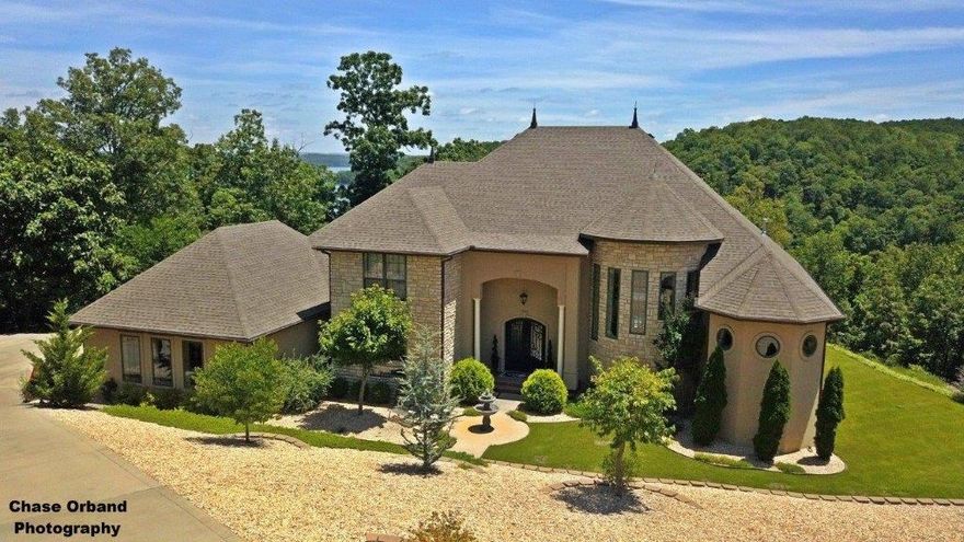 ONE WORD..VIEW!   You will never want to leave this lakefront oasis only 14 minutes from downtown Rogers!  With complete privacy, this backyard paradise boasts concrete balconies and decks with gorgeous lush landscaping.  This 3 bedroom plus bunkroom home has it all! This custom home was built with (ICF) integrated concrete foam walls making it resistant to termites, extreme weather, sound proof and extremely durable. Some of the many amenities include: cathedral ceilings, crown molding, large kitchen with extensive storage, stainless steel appliances, open concept to living room which features a beautiful fireplace, incredible master walk-in shower, platform tub, double vanity, built-ins, two living areas, dining room, marble floors, an abundance of natural light from floor to ceiling windows, and all lower level rooms look onto the stunning pool area.  This home comes with a boat slip and access is via a concrete trail.