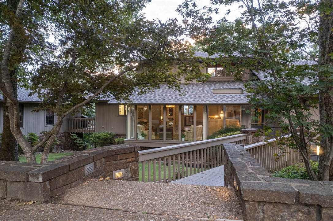 SELLER SAYS SEND ALL OFFERS! Nestled on a lush lot in Fianna Hills, this beautifully designed residence offers stunning views and a park-like setting. The home features 4 bedrooms, each with an ensuite bath, totaling 4.5 bathrooms. The oversized master suite is filled with natural light, vaulted ceilings, and a spa-like bath with soaking tub, dual vanities, and a large custom closet. The main level includes the master, a second bedroom, living and sitting rooms, kitchen, dining, and laundry. The kitchen offers cherry cabinetry, granite, pantry, island, beverage fridge, stainless appliances, and gas range, with dining overlooking Mount Magazine. Upstairs is a third bedroom, full bath, and reading nook. The lower level has a fourth bedroom with bath, living room with fireplace, bar, office, and game room with flagstone floors—ideal as a mother-in-law suite. Decks on every level capture year-round views. Seller includes a 1-year warranty and option to purchase fully furnished.