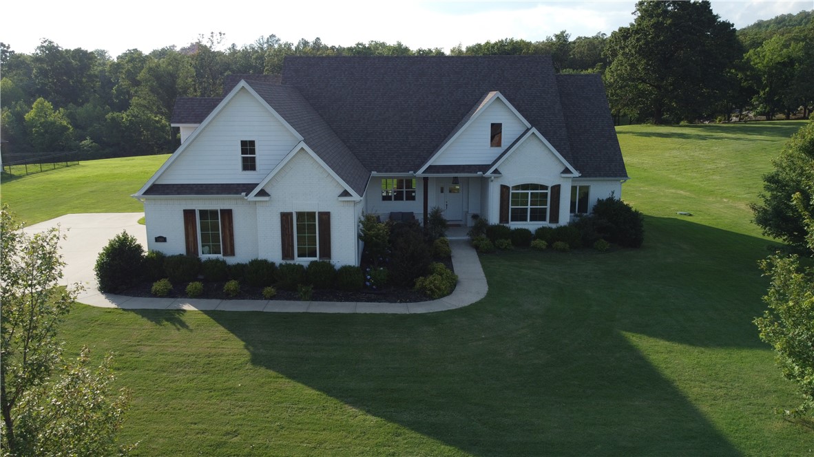 Welcome to your peaceful retreat in the Knolls Subdivisionāwhere nature, comfort, & custom style meet. This one-owner modern farmhouse sits on a scenic 2-acre lot & features 4 bedrooms and 4 baths with thoughtful design throughout. The open-concept living area is filled with natural light and panoramic views. The gourmet kitchen includes high-end appliances, a farmhouse sink, fridge to convey & a large island for meal prep or entertaining. Enjoy both a cozy front patio and a spacious back patio, perfect for outdoor dining and sunsets. The primary suite offers hardwood floors, two walk-in closets, and a spa-like bath with double vanity and jacuzzi tub. Upstairs includes a large bonus room with full bathāideal for a guest suite or playroom. One bedroom is perfect as a home office.3-car garage with Level 2 EV charger, accent lighting, custom stonework, in-ground basketball goal, epoxy flooring in garage with smart app & central vac. Has access to neighborhood pool, clubhouse, tennis/pickleball courts, & walking trails