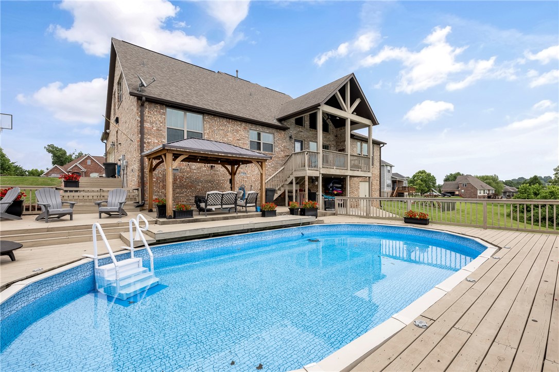 Set on over 1+ acre w/ serene views of open pastures, this home offers a blend of space, function, and style. In 2019, extensive renovations brought new life throughout: the kitchen was completely remodeled with granite countertops, custom cabinetry, updated lighting, stainless appliances, added cabinets, and a redesigned pantry. The main bathroom now features new: tile, frameless glass walk-in shower , soaker tub, cabinetry, and granite. A 2nd bath was reconfigured with a new walk-in shower, and the laundry room was upgraded with new tile, cabinetry, and a utility sink. Fresh paint was completed throughout the home the same year. The in-ground pool was enhanced in 2024 with a new liner, pump, and stairs, designed with a deeper center for swimming and lounging. Outdoor living is extended with a wraparound stained deck and a pergola added in 2023. A half bath in the unfinished basement offers easy access for pool guests. Distance Springdale, Fayetteville-15 minutes & Rogers/Bentonville 30. Elect. in storage bldg.