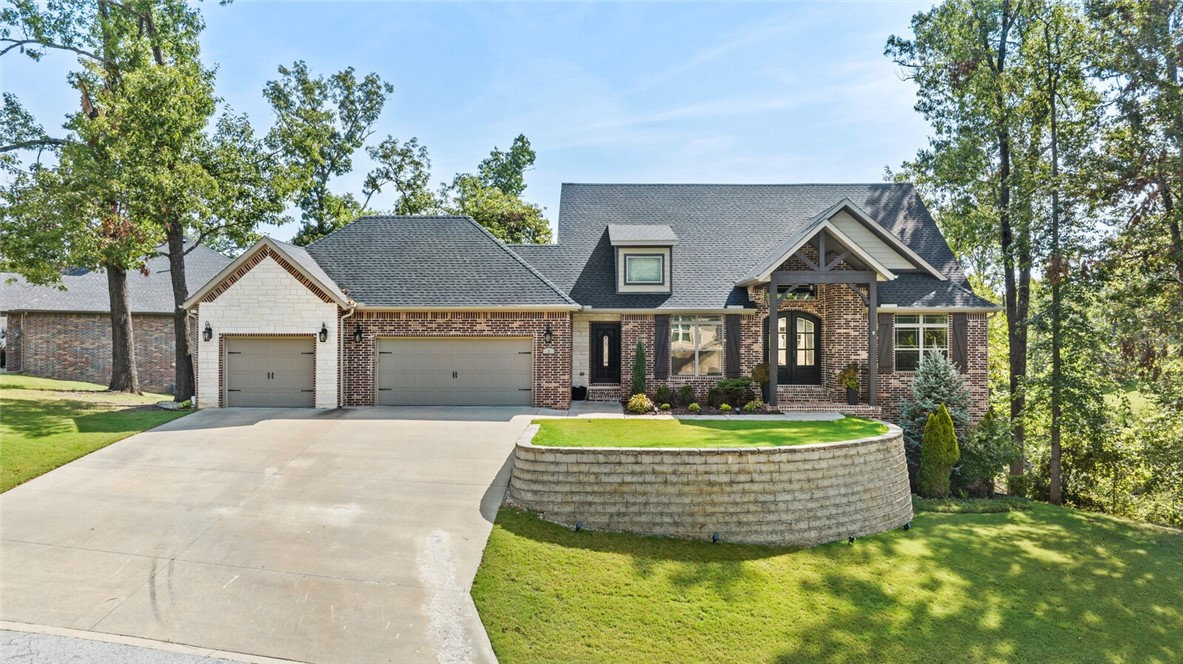 Stunning Woods Creek home with quick access to I-49, downtown, nearby trails, and the new Wal-Mart HQ. Enter through grand double wood doors into an upscale, open-concept layout. The gourmet kitchen features soft-close cabinets, Thermador 6-burner gas cooktop, pantry, and island with seating. The living room has wood floors, a gas fireplace, and double doors opening to the covered deck with serene treelined views. The primary suite connects to the deck and includes an ensuite with tiled wet room with soaker tub and closet with direct access to the laundry room. The main floor also includes a bedroom/office, half bath, and a drop zone. Lower level boasts a massive bonus room, 2 bedrooms, full bath, workshop, workout space with rollup door, and covered patio. This home features elegant details and practical amenities like security, central vac, infrared heater on patio, NEST, & surround sound. Updates: new roof, gutters, epoxy flooring, and two decks. Enjoy POA amenities including a playground, pavilion, and pool.