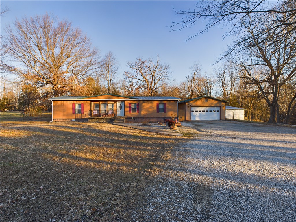 This rural property, located south of town, offers a spacious workshop building and a double-wide manufactured home. The home features a large living area, with three bedrooms and two bathrooms, making it ideal for families or those seeking extra space. The deck includes a handicap ramp that can be removed if not needed, providing added flexibility. This property is perfect for those looking for privacy and room for projects or storage, with easy access to town amenities.