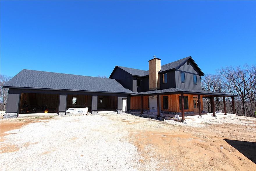 New Construction on 11.28 acres not far off of I-49 at West Fork. This modern country home is built well and much more like a custom home than your typical spec. Over 6000 sqft under roof including a large wraparound porch, approx 40x 50 garage that's heated/cooled with its own min-split and a huge storage room upstairs. This energy efficient home has foamed walls and roof deck so everything inside is conditioned. Primary suite is downstairs with 2 large closets and one opens to the utility room. Living room has tons of windows for natural light, a wood burning fireplace and over 20' ceilings. 3 bedrooms, 2 baths plus a living space upstairs. Property also features a metal shop building (24x30) and a small horse barn. Hurry to pick your interior colors.