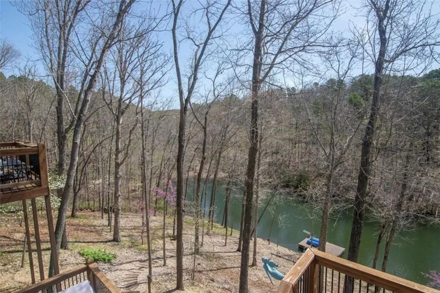 Rare opportunity for a lakefront custom built home with dock that is 10 miles from Walmart Headquarters and next to the Back 40 trail in Bella Vista.  This Lake Rayburn home boasts comfort, charm, openness, tons of windows and views, multiple outside decks, high-end finishes and appliances, a open concept plan with bonus loft, a lower level rec room, and a private swim and fishing dock.  The expansive double lot borders POA common property at the end of a cul-de-sac, giving you room to breath.  Escape into the beauty of Bella Vista and the lake, fishing, biking, hiking, nature, BV ameninities and relaxing lifestyle, while still 15 minutes from downtown Bentonville and Walmart Headquarters.