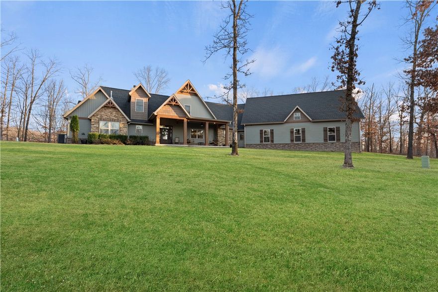 Custom-built home in a wooded setting.  This craftsman style home features an open living/dining/kitchen area with gorgeous hardwood floors throughout and vaulted ceiling with a beautiful bank of windows extending all the way to the apex of the vault.  The dedicated dining area leads you into the spectacular custom cabinetry of the kitchen, with granite countertops, and pantry with antique door. The primary suite has a full glass double door that leads onto the covered back patio, with a spot pre-wired for a hot tub. The ensuite bath has gigantic double head shower, separate vanities, and huge closet, all anchored by a gorgeous soaking tub. The other 2 main floor bedrooms are attached by a true Jack-n-Jill bath. Upstairs bonus room and HUGE bedroom with closet and full bath. Humongous garage with lots of extra storage, and the showstopper is the 1000 ft of unfinished storage space above the garage. The outdoor area is to die for with quad full glass doors leading to the vaulted covered patio. MTB trails all around.