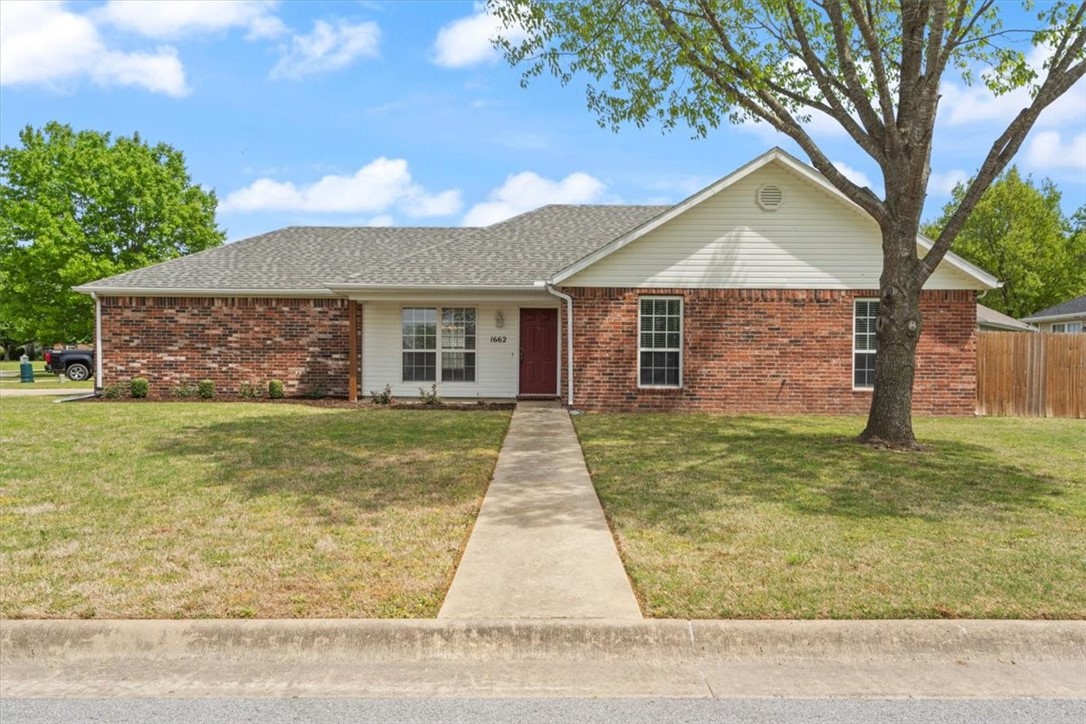 This home in Huntclub subdivision sits on a corner lot with a side-entry garage. It has 3 bedrooms and 2 baths. The living room has a corner gas log fireplace and vaulted ceilings. It's next to the bright dining area, back exit, and galley kitchen. There is wine storage above the large fridge space and plenty of storage. Primary bedroom has laminate wood flooring and vaulted ceiling to match the living areas. Outside, enjoy a large yard with privacy fence. This home is close to Lake Wilson Park and Lake Sequoyah Park, and just down the road from Downtown Fayetteville.