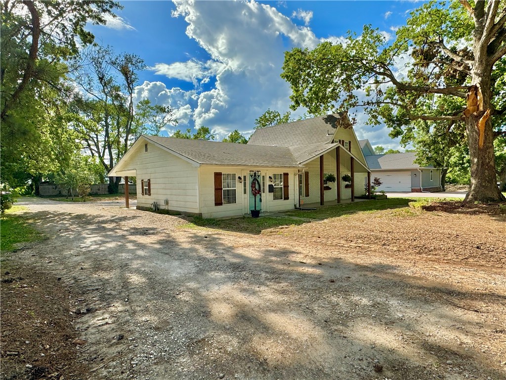 This English Tudor is centrally located between downtown Bentonville, Crystal Bridges and Orchard Park, 8th Street Market and Arts District, and the new Walmart Global Campus. This home is on a beautiful level lot with established shade trees and fruit trees, with an additional greenhouse. There are two ensuites downstairs and two bedrooms and bath upstairs. The open concept living space downstairs makes a nice flow from the kitchen to the living room. The updated kitchen boats Dolamite counters, Italian brick backsplash, new double ovens, microwave, sink, dishwasher, and cooktop. New interior paint throughout. This would make a great rental or would be easy to add on to if you need more space. Motivated Seller, Bring an offer.
