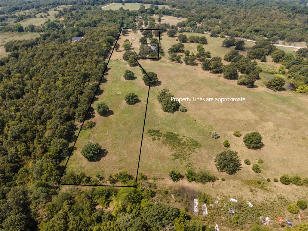 6.9 Acres on top of a picturesque Ozark Mountain with a great rustic barn. There are many options. Use as is, expand on the existing space, remodel into a home or build your dream home on one of the many available spots. The property has been used for a wedding venue, parties, get togethers and more. There is over 4,000+ SF of usable space. This charming property provides the ideal back drop for these events. Featuring a full kitchen w/bar, 3 half baths, (no bedrooms), large hosting area, heated and cooled 240 SF bridal suite, corrals and more! The event area has a projector to showcase anything you would like. The property runs on a well with numerous frost-free taps around the place. City water is already run to the barn but is using the well at the moment.