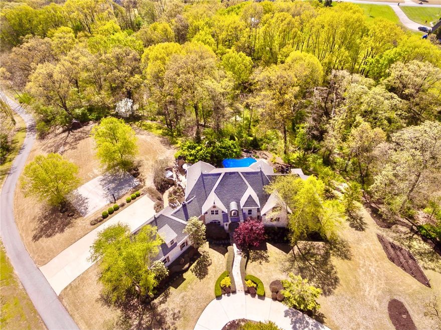 Luxury resort style living located on a beautiful & private 3.17 wooded acres offering everything you are searching for & more! Four spacious living areas, private heated pool w/slide, guest apartment, 700+ bottle wine cellar, theater room, home office & gourmet high end kitchen are just a few of the features to impress! Oversized Master Suite boasts a boutique style closet that is jaw dropping, along w/one of 3 laundry rooms! Outdoor kitchen, wood burning FP, hot tub, BB court, soccer field, rear entry 3 car garage. New roof in 2021 along w/countless other recent upgrades!