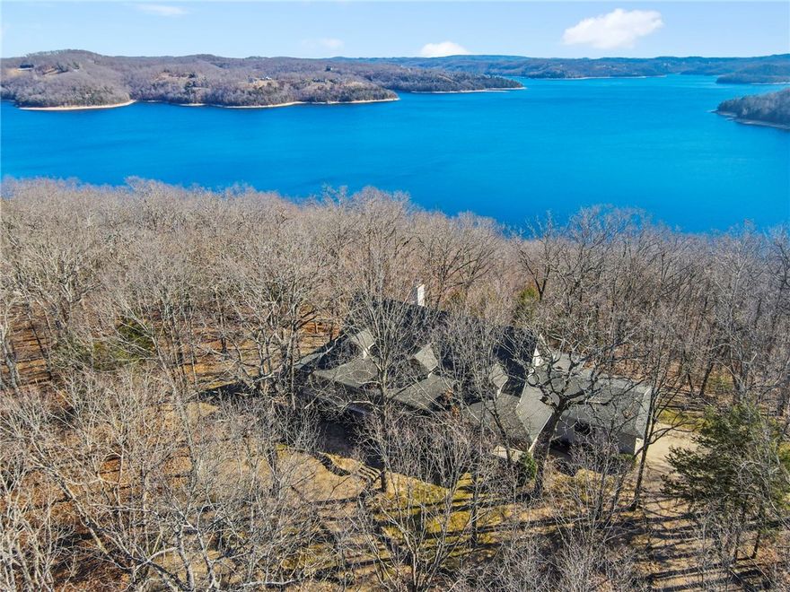 Perched atop Red Bluff Peninsula on Beaver Lake, this custom home offers rare nearly 360-degree panoramic lake views that change with the seasons. Designed for true lake living, it includes a private boat dock just minutes away by foot or ATV. Inside, the great room features soaring ceilings and a striking two-story wood-burning fireplace, with custom details throughout, including white oak beams in the kitchen. An oversized utility room offers exceptional storage and flexible use. Outdoor living is highlighted by an 8-ft-wide wraparound porch with 9-ft ceilings and sweeping lake views. Additional features include an encapsulated crawl space, a dock with an electronic lift, and a powered workshop. A rare opportunity for privacy, lake access, and unforgettable views, with an option to purchase an additional 3.61 adjoining acres. Also listed as MLS #1331853, this is the 3.61 acres that are also for sale if desired. Ask agent for information.