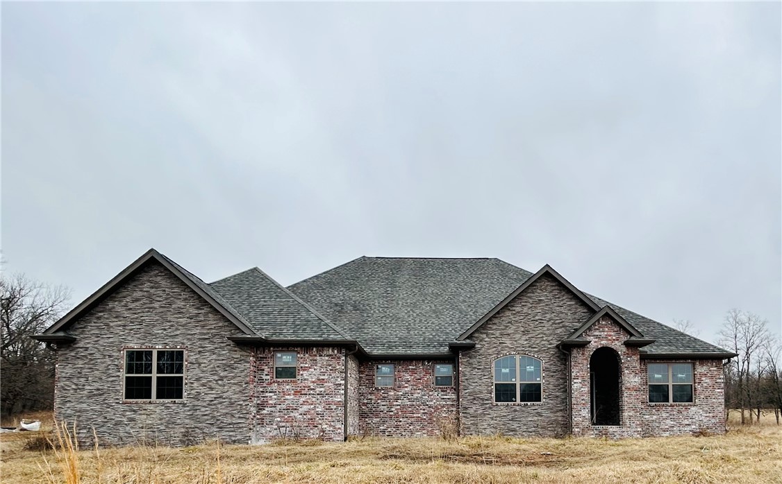 Incomplete new construction waiting for your final touches to make your dream home. BY APPOINTMENT ONLY! Beautiful Brick and Stone, 3400 sq foot heated and cooled, 4 bedroom 3 1/2 bath with 4 car garage (insulated doors) 9.75 acres on Spavinaw Creek. This home has 1000 gal buried propane tank, septic tank installed, 400 Amp service will provide plenty of power to add a shop, HVAC electric with propane backup, 10yr parts and labor warranty installed,complete with ductwork sprayed with foam insulation, exterior walls and ceiling are foam insulated, interior walls insulated with batts for noise control. Exterior includes gutters. Great open concept with a large walkin pantry. Master closet is a concrete lined storm shelter. All bedrooms wired for wall mount TV. Plumbed for central vac, wired for aprox 63 can lights, additional breaker box in laundry to add on. Plumbing and electric is all roughed in, sheetrock textured and primer. Great private location, beautiful view,8 mi to I49.Generator and Central Vac installed