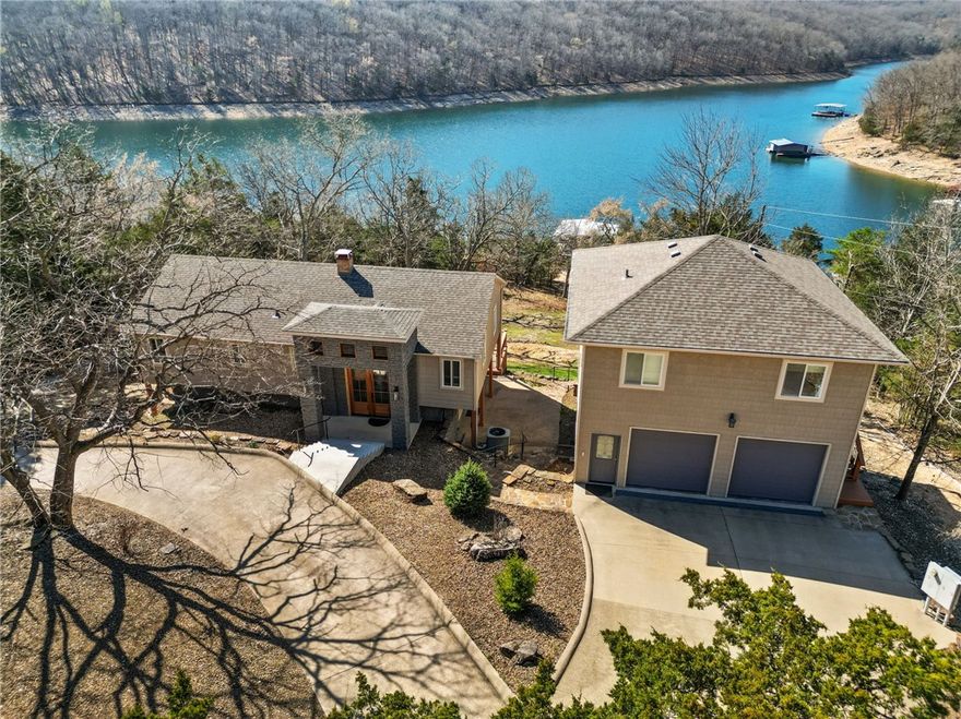Your lake life needs this lake front with a walk to your private boat dock on Beaver Lake just south of Point 2 on the Indian Creek arm.  A brand new entry with elegant 8 foot doors and new concrete steps leading to a bright space with lake views from almost every window in the house.  Custom cabinets and clean decor ready to customize.  The two-car garage includes a shelter/wine cellar underneath and a luxurious apartment above with its own large deck.  A two slip private dock with boat lifts, swim deck and a jet-ski landing promise memories of every pretty summer.  Come and live in this peaceful, quiet lake neighborhood.  Roof shingles and gutters are all new in 2024, and hot-tub and all appliances convey with this home.