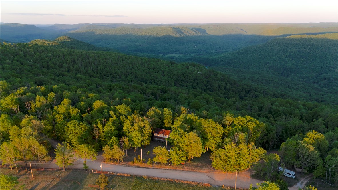 Tucked just 3.5 mi off Hwy 21, this 1,408± sq ft home on 4± acres offers big potential for the right buyer with vision. Need a fixer-upper with investment upside? You’ve found it—ideal as a mountain retreat, rustic Airbnb, or outdoor basecamp. Only 12 mi from Boxley Valley (elk!), 16 mi to Ponca & the Buffalo River, and minutes from Glory Hole Falls & Hawksbill Crag. Just ¾ mi to thousands of acres of public land—perfect for hunting or trail access. The home needs TLC & cleanup, with unfinished areas ready for your personal touch. Utilities in place: electric, rural water, and propane! Set in the Ozark Mountains with sunrise/sunset view potential—clear a few trees, add a deck, and take in the beauty of the valley with the Little Buffalo River below. Being sold AS IS—but priced accordingly. If you’ve got some vision and elbow grease, this could be something truly special. Rare opportunity in an incredible location—don’t miss out!