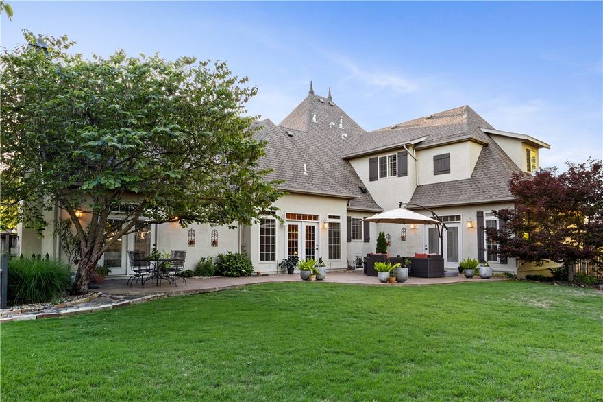 Prime Location!! Just a short hop from the bypass, enter your chic gated neighborhood (w/pool), and be welcomed by your stunning home on .5 acre corner lot. This 4 bed, 3.5 bath home offers 3,881 sqft of thoughtfully designed space in a park-like setting. Step inside to soaring, beamed ceilings, floor to ceiling windows, 3 stone fireplaces, sunlit living spaces, custom built-ins, and spacious rooms. The Eat-in Chef’s kitchen is built for function and style w/granite counters, gas cooktop, double ovens and pantry. From the kitchen look out onto a light filled family room w/ fireplace that opens onto your sprawling, gated yard. Split floor plan, the primary suite w/ fireplace and a guest suite can be found on the main level. Upstairs, you'll find two bedrooms, with Jack n’ Jill bath, plus bonus/media room. A large outdoor patio welcomes you to relax and enjoy the beautifully manicured lawn and garden. The community includes pool & direct access to the Railyard Loop Trails, connecting you to all of NWA.