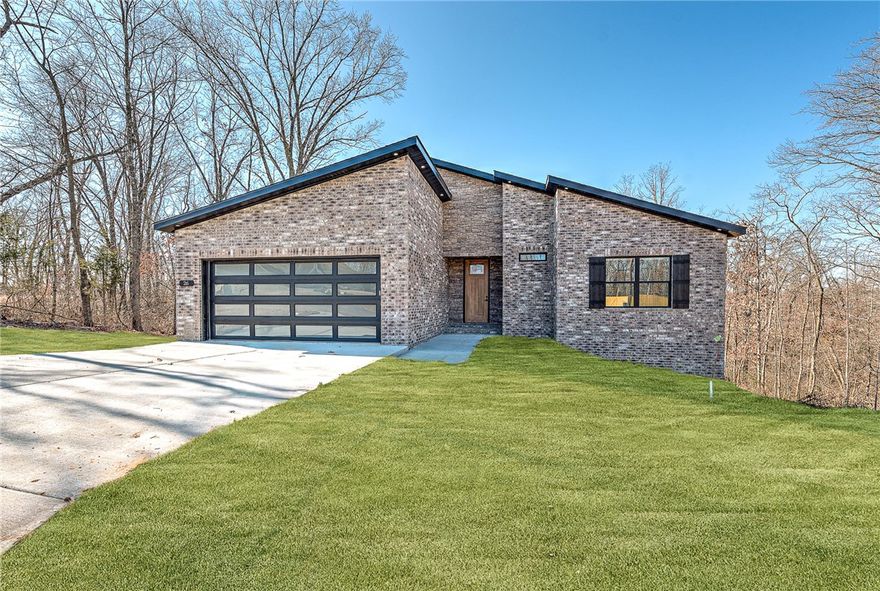 Brand new 3 bedroom, 2 bathroom home with 2-car garage located in desirable Bella Vista, Arkansas. This thoughtfully designed new construction offers an open-concept layout w/luxury vinyl plank flooring throughout the main living areas and a bright, neutral color scheme. The spacious living room flows into the kitchen and dining area, creating an ideal space for entertaining or everyday living.The kitchen features modern cabinetry, stainless steel appliances, ample counter space,& a center island w/ bar seating. The primary suite includes a private en-suite bathroom & generous closet space, while two additional bedrooms are perfect for guests, family, or a home office.Enjoy the peaceful wooded surroundings from the back deck. Additional highlights include a 2-car garage, energy-efficient construction, recessed lighting, and low-maintenance exterior materials. Conveniently located near Bella Vista’s golf courses, lakes, trails,& amenities, this move-in ready home offers comfort, quality,& the Bella Vista lifestyle.