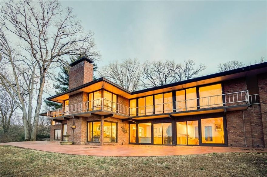 Stunning panoramic lakeview, exquisite architecture, breathtaking sunrises, luxury finishes, modernism at its finest…this artistically and meticulously designed home has it all. Designed by architect Warren Seagraves who brought international-style modernism to NWA. Situated on multiple lots (development potential) on a private hilltop, solid maple floors and doors, 4 bedrooms, 4 full bathrooms, 2 half baths, lakeviews from all living spaces plus panoramic lake views from the master suite and lake/nature view from oversized whirlpool tub. Entire walls of windows yet completely private due to masterful design. Gutters with waterfall downspouts that flow into french drains, whole home natural gas generator, Sub-Zero refrigerator/freezer, lower level wet bar, new upper level AC compressor, new lower level HVAC system, wired for Cat5 internet and so much more.