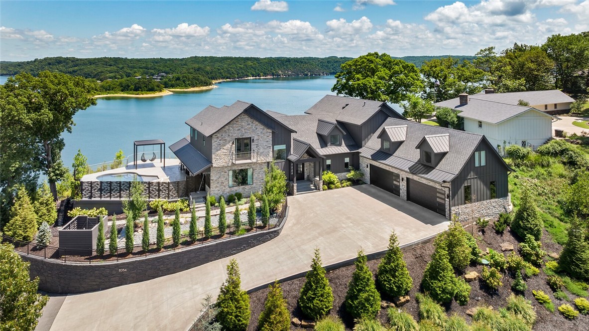 This luxurious custom-built Beaver Lake Estate has arguably one of the best panoramic views the lake has to offer. Featuring lakeside 10 Foot sliding doors by Pella (w/ window treatments from Restoration Hardware) that showcase the stunning views from almost every room in the home. Resort style amenities in the outdoor retreat that includes 2 custom metal pergolas, Hot Tub, Gunite Pool with pebble tech and hybrid heater, Outdoor heaters, stainless steel fence, outdoor kitchen with Blaze Grill, fridge & sink. Gourmet Kitchen with JennAir® appliances has two quartzite islands w/waterfall edge, Double Oven, pellet ice maker , marble countertops, soft close doors and drawers, built-in MIELE coffee maker and gas cooktop w/ pot filler. Quality abounds in this stunner with entire home generator, full irrigation, spray foam insulation, triple pane Pella windows, white oak floors, water filtration system, Tankless Water Heater, Polished 4 car garage floor, Surround sound, Brilliant™ light switches/dimmers.