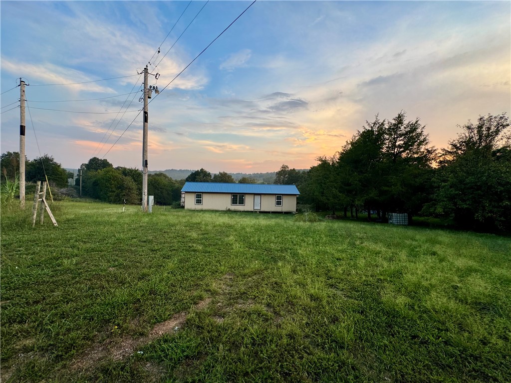 Endless possibilities in these beautifully secluded 5 acres outside of City Limits. No POA, Deed, or Covenant Restrictions. Property comes with a private pond, five pear trees, two apple trees, and plenty of additional acreage to enjoy. Property sits at end of Private Road and within 10 minutes of Hwy 412 and only 25+/- min away from Huntsville, Springdale or Fayetteville. Existing Mobile home is of no-value and conveyed as-is.
