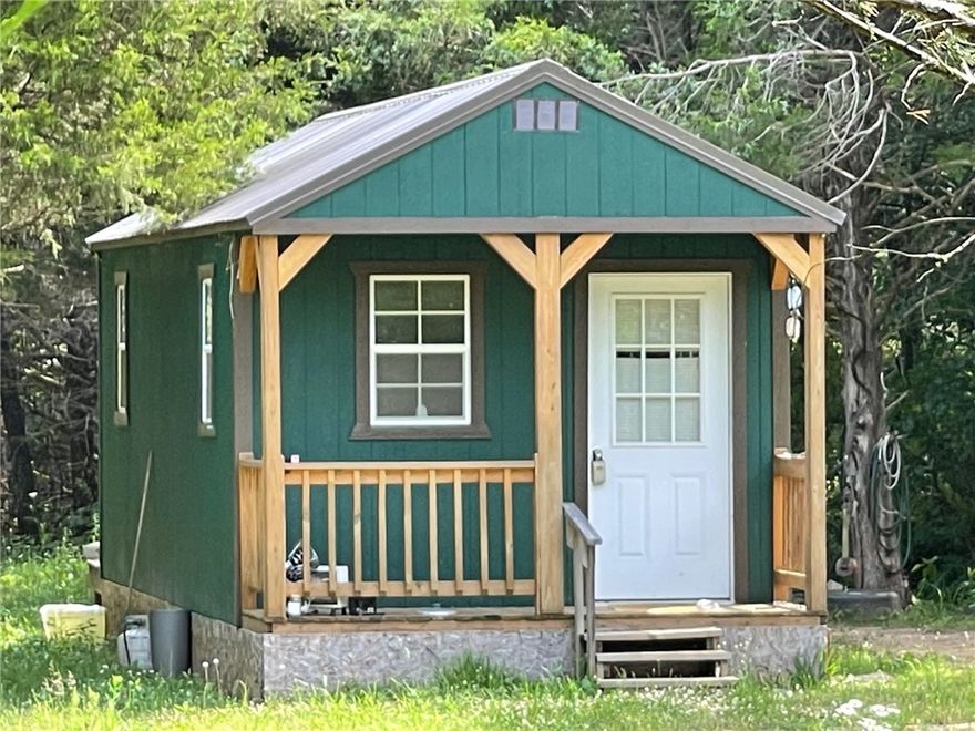 Investment property! 3+ acres with 1200 Ft. approximately of Highway 412 frontage.  Fixer upper home with 3 bed, 2 bath in 1215 sq. ft. Mobile.  There is also a 336 sq. ft. Dirksen building that could be fixed up into living quarters.  Secluded in the trees, either could be fixed up into nightly rental or just rental.  Well and Septic needed.