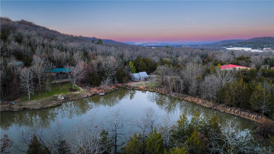 A literal ONE-of-a-KIND Fayetteville property. Welcome to your very own 5 acre paradise. This picturesque setting looks like something out of a Norman Rockwell painting. Value is mostly in the land and location.
 Rustic cabin built in 2002 with these updates in 2025: new roof, new exterior paint, interior paint, stacked washer/dryer, refrigerator and electric heater.  So tranquil & relaxing. Cabin has one BR on main level, while boasting upstairs loft for secondary room.  Breathtaking backyard with 2 acre pond & beautiful woods on the south. Want to AirBnB ? Razorback weekend get-a-way? If you've been dreaming of a unique property w/ TONS of options under $280K, come check out the most unique listing on the market. Close to Drake Field Airport, you’ll have the most
beautiful take-offs & landings with the ducks and wildlife. An "away" retreat, but still only 10 minutes from the University of Arkansas and Dickson St.
