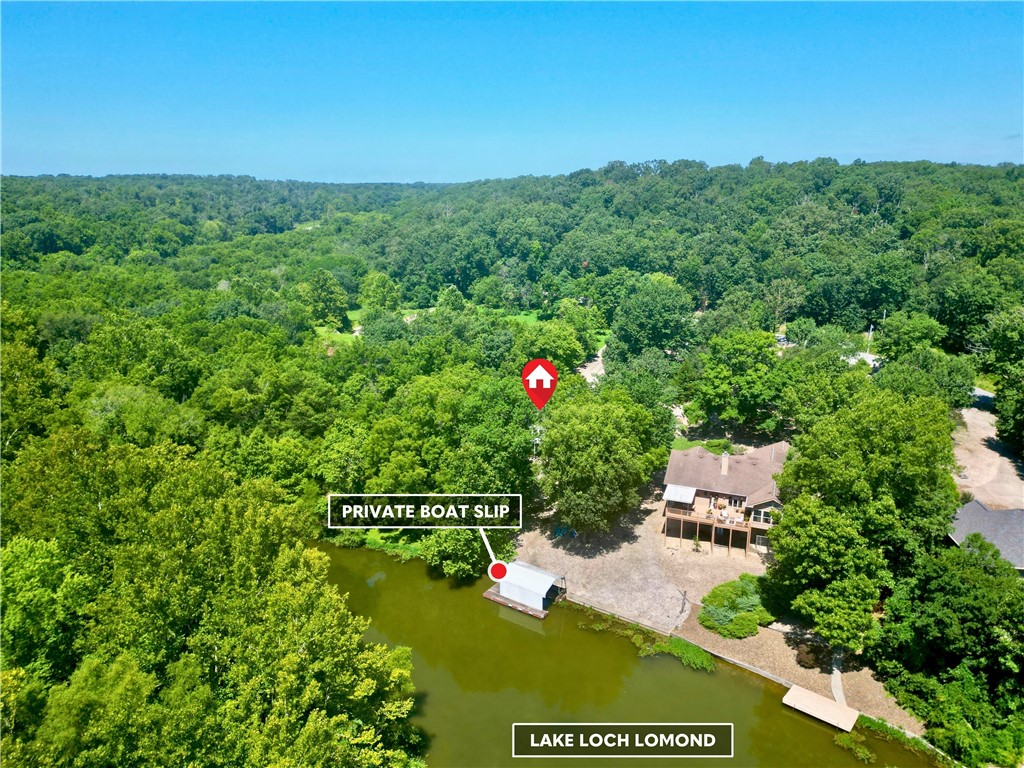 Lake living at its finest on Loch Lomond! Welcome home to 3BD/3BA property with office & downstairs bonus room offers an easy, level entry and a gentle walk to the water. Enjoy your own covered boat dock and a low-maintenance rock yard. The vaulted ceilings and open layout connect the living, dining, and kitchen areas — complete with granite counters, custom island, and extra storage. Take in serene lake views from the 4-season enclosed porch or the spacious back deck overlooking the level yard. The walk-out basement includes a 3rde bedroom and bonus space/second family room. Updated primary suite features a walk-in shower, whirlpool tub & dual vanities. 3-car garage, walk-through laundry access to the kitchen on primary floor. Whether boating, relaxing, or entertaining, this lakeside retreat has it all!