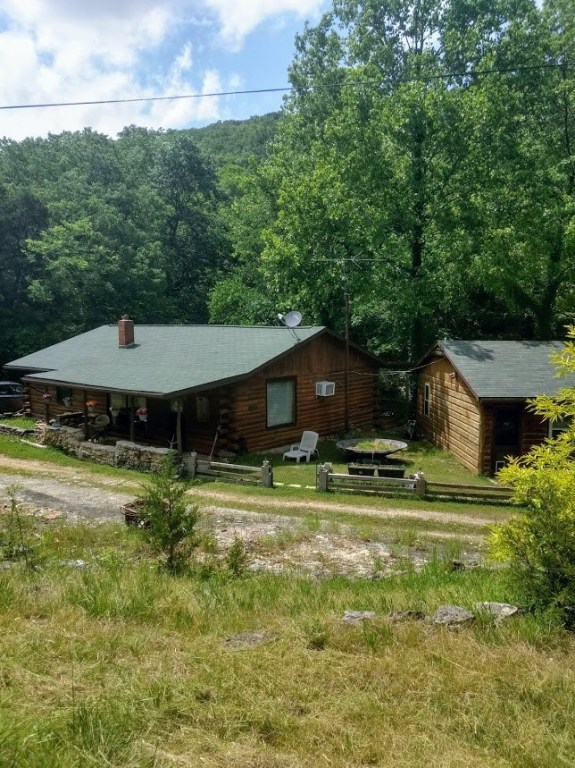 Log home (2 bed 1 1/2 bath) and guest cabin (1 bed 1 bath) sit together on two beautiful acres Located just a few miles outside of Eureka Springs and a few minutes away from Holiday Island Marina. Live in one cabin and use other for in-laws or possible rental. Both cabins come fully furnished! You can have country living just a few miles from shopping, churches and social activities. Plus Water Filtration System and Propane Backup Generator.