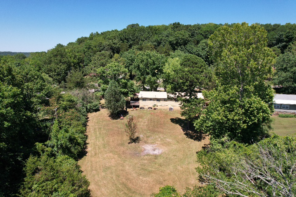 An open concept living space, set among mature trees on.90 acre with space for RV parking and fenced backyard park like setting. Generous storage off carport. Mature trees with amazing shade and shrubs. Newer roof, new , cozy wood stove, covered deck to have coffee in the mornings, extra seating for breakfast. Refrigerator, washer/dryer to convey. Close to school, public park by the River with walking trails, Harps Grocery. Small town with easy access to 71 and 49. 8 Miles to Fayetteville.
