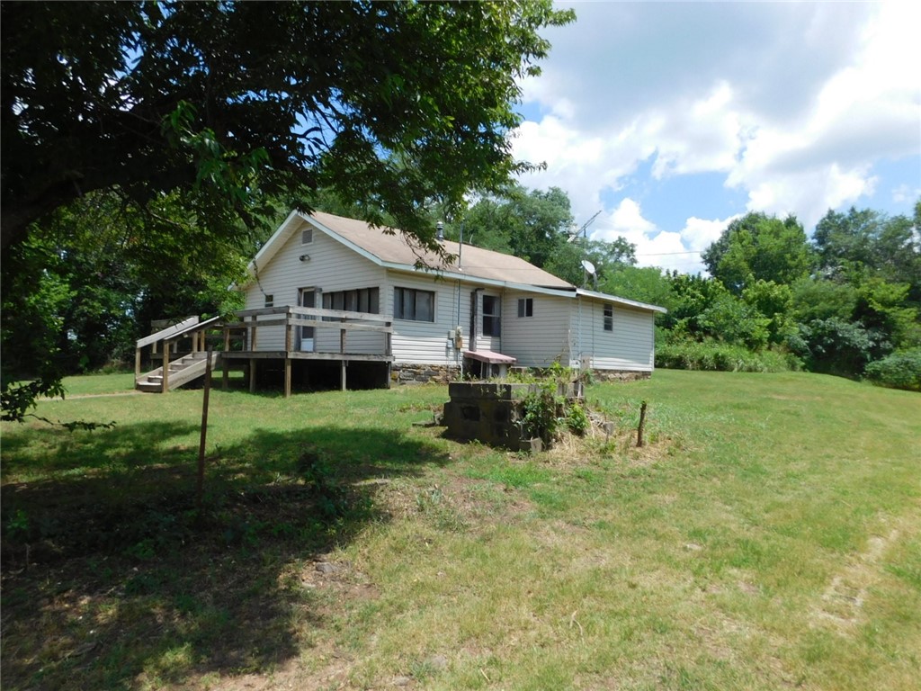 This is a great opportunity for the right family! The home is in good condition but does need some work. It offers a great kitchen (with refrigerator), a new water heater, really nice remodeled bathroom, a newer mini-split HVAC unit, a woodstove, 2-3 bedrooms, front porch and deck, functional outbuildings used for woodworking (with electricity), fruit cellar, and plenty more. Property is right in the middle of town where a new children's playground is being built, and close to the post office and fire department. The roof does need to be replaced and there are no washer/dryer connections. Sold AS-IS, no repairs